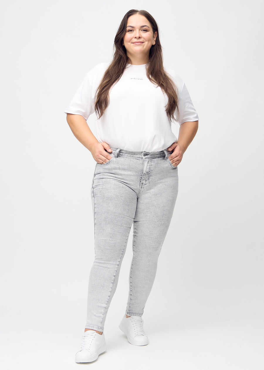 Gesamtbild eines Plus-Size-Models in hellgrauem Denim skinny jeans.