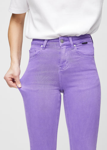 Skinny-Jeans für Damen in Lila, Farbe Lavenders. Ein Model dehnt den Jeansstoff am Oberschenkel, um den Stretch zu zeigen.