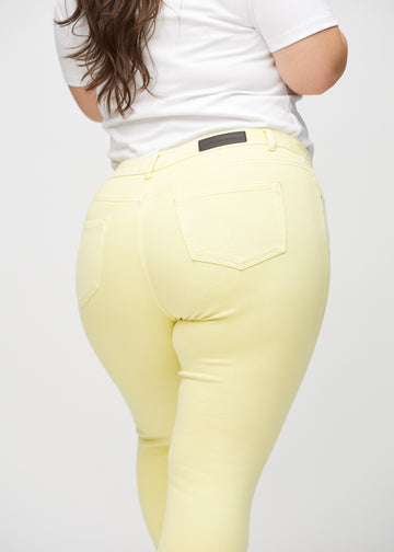 Hellgelbe skinny jeans von hinten aus der Nähe an einem Plus-Size-Model gesehen, um Details zu zeigen.
