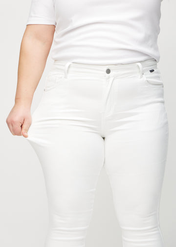 Skinny-Jeans für Damen in Weiß, Farbe Marguerites. Ein Plus-Size-Model dehnt den Jeansstoff am Oberschenkel, um den Stretch zu zeigen.