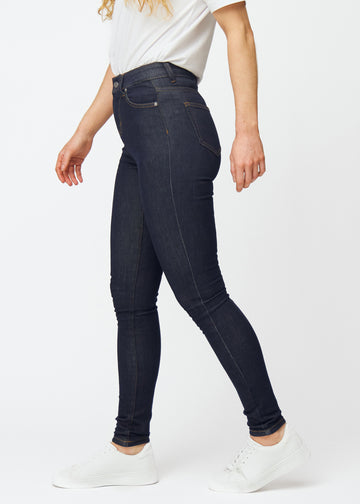 Tief dunkelblaue Denim jeans für Damen in der Farbe Midnights mit skinny Passform, von der Seite am Model gesehen.
