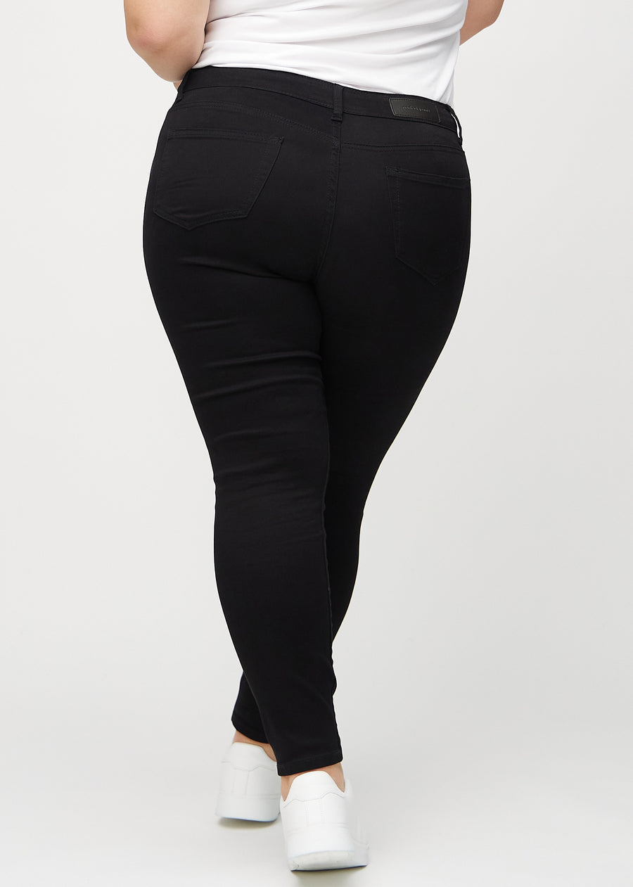 Skinny-Jeans für Damen in Schwarz, Farbe Ravens. Rückansicht an einem Plus-Size-Model, die gesamte Passform ist zu sehen.