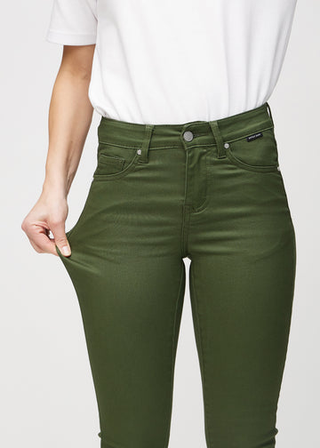 Skinny-Jeans für Damen in Dunkelgrün, Farbe Renewals. Ein Model zieht am Jeansstoff am Oberschenkel, um den Stretch zu zeigen.
