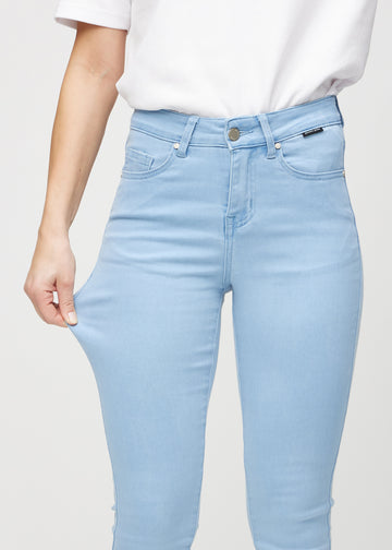 Skinny-Jeans für Damen in Hellblau, Farbe Skies. Ein Model zieht am Jeansstoff am Oberschenkel, um den Stretch zu zeigen.
