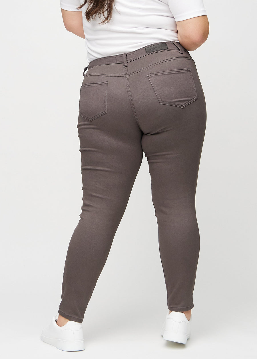 Graubraune skinny jeans von hinten an einem Plus-Size-Model gesehen, damit man das gesamte Produkt sehen kann.