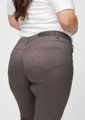 Graubraune skinny jeans von hinten aus der Nähe an einem Plus-Size-Model gesehen, um Details zu zeigen.