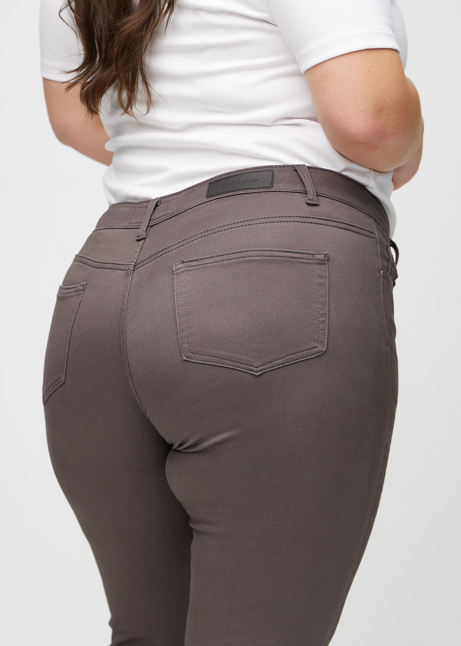 Graubraune skinny jeans von hinten aus der Nähe an einem Plus-Size-Model gesehen, um Details zu zeigen.