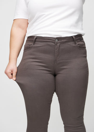 Das Plus-Size-Model dehnt die Jeans am Oberschenkel, um den Stretch zu zeigen.