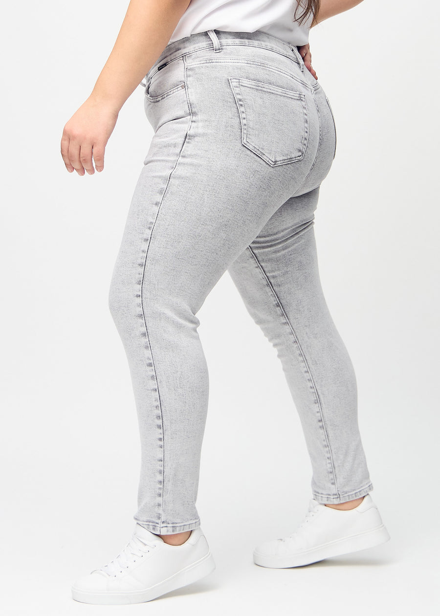 Hellgrauer Denim slim jeans von der Seite an einem Plus-Size-Model gesehen.