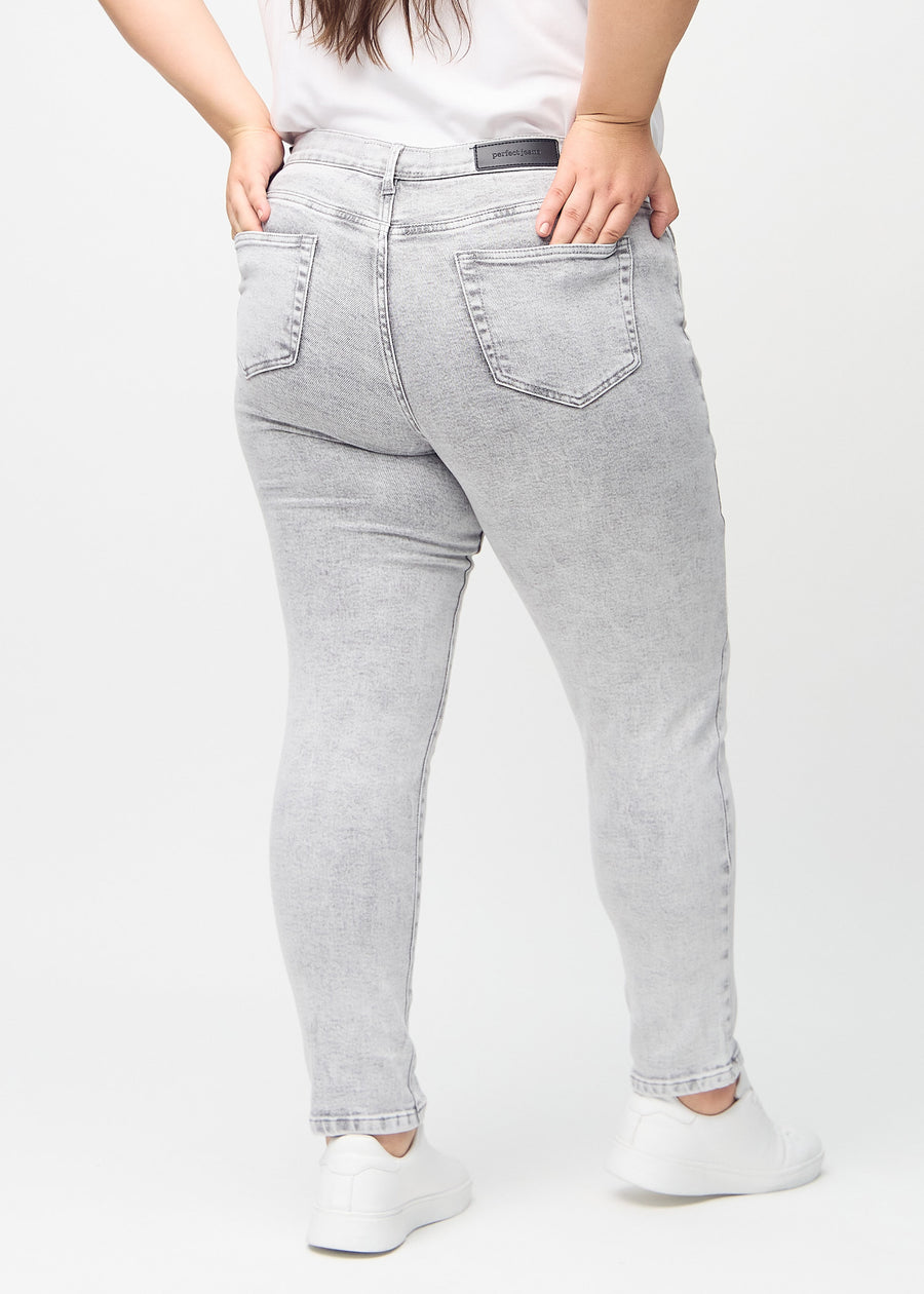 Hellgrauer Denim slim jeans von hinten an einem Plus-Size-Model gesehen, damit man das gesamte Produkt sehen kann.