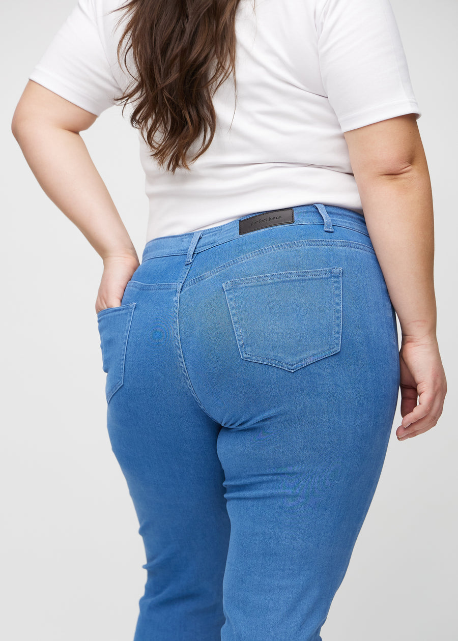Slim-Jeans für Damen in Blau, Farbe Geraniums. Nahaufnahme der Rückseite an einem Plus-Size-Model, die Details sind gut erkennbar.