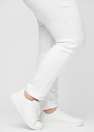Slim-Jeans für Damen in Weiß, Farbe Marguerites. Nahaufnahme an den Knöcheln eines Plus-Size-Models, um die Passform am Beinabschluss zu zeigen.