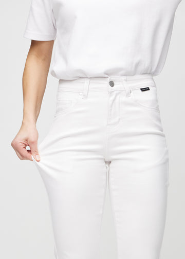 Slim-Jeans für Damen in Weiß, Farbe Marguerites. Ein Model zieht am Jeansstoff am Oberschenkel, um den Stretch zu zeigen.