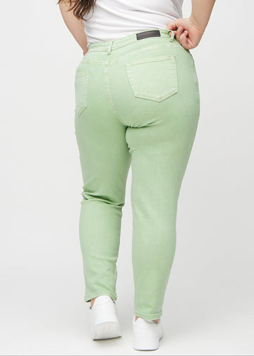 Hellgrüne slim jeans von hinten an einem Plus-Size-Model gesehen, damit man das gesamte Produkt sehen kann.