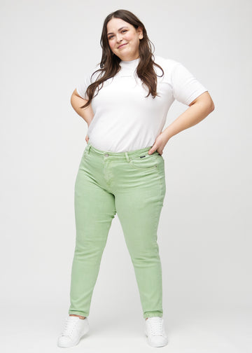 Ganzkörperbild eines Plus-Size-Models in hellgrünen slim jeans.