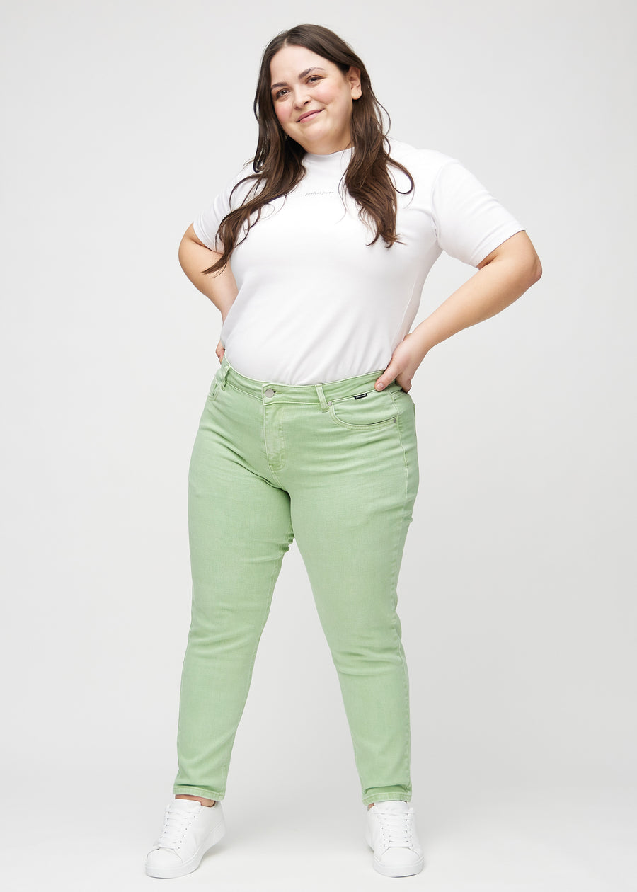 Ganzkörperbild eines Plus-Size-Models in hellgrünen slim jeans.