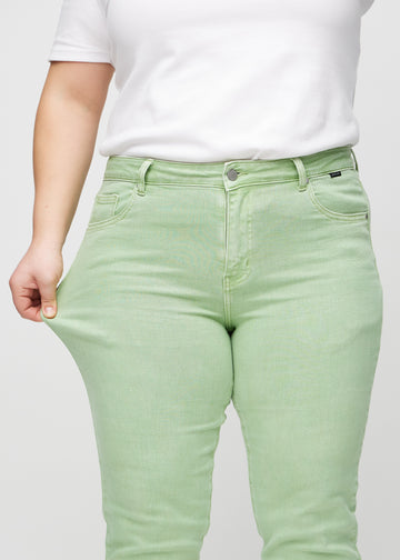 Das Plus-Size-Model dehnt die Jeans am Oberschenkel, um den Stretch zu zeigen.