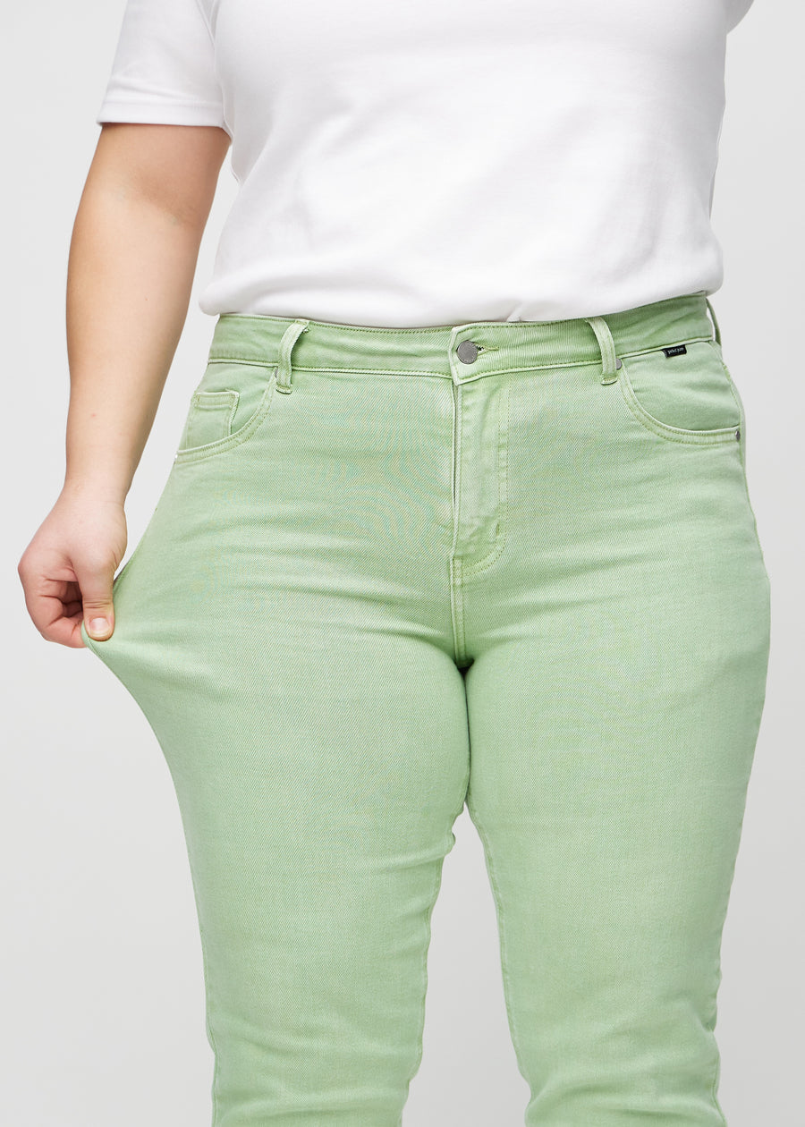 Das Plus-Size-Model dehnt die Jeans am Oberschenkel, um den Stretch zu zeigen.