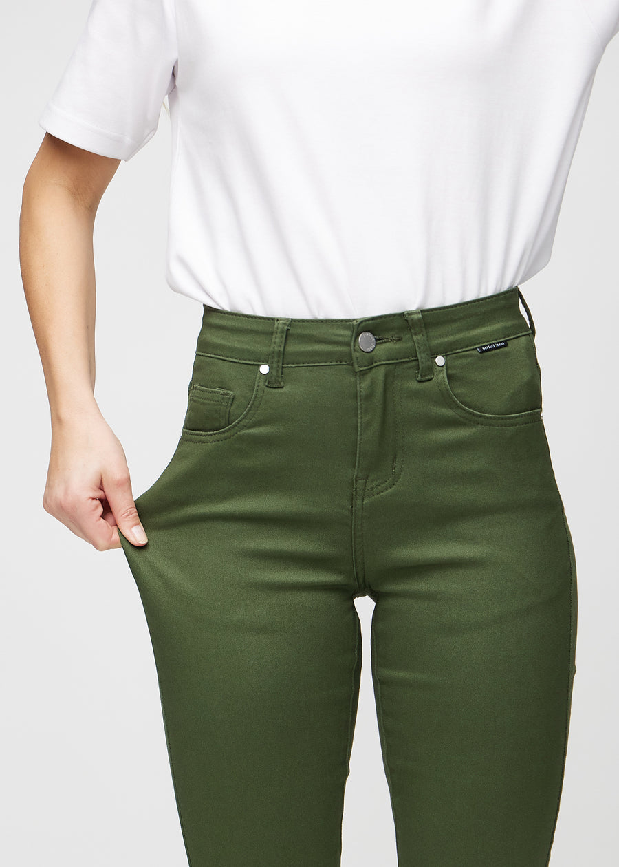 Slim-Jeans für Damen in Dunkelgrün, Farbe Renewals. Ein Model zieht am Jeansstoff am Oberschenkel, um den Stretch zu zeigen.