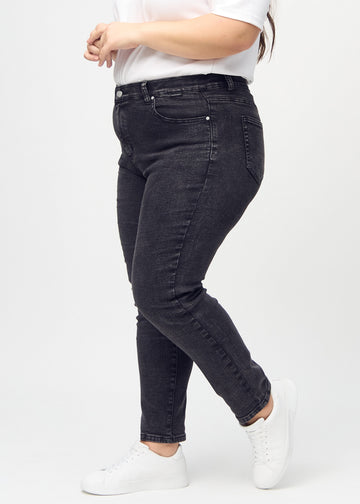 Dunkelgrauer Denim slim jeans von der Seite an einem Plus-Size-Model gesehen.