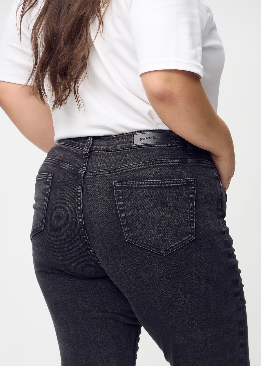 Dunkelgrauer Denim slim jeans von hinten aus der Nähe an einem Plus-Size-Model gesehen, um Details zu zeigen.
