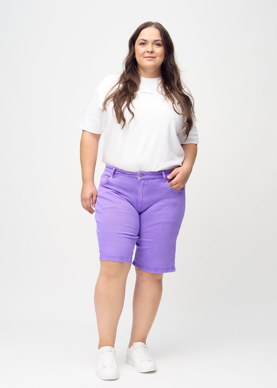 Ganzkörperbild eines Plus-Size-Models in lila regular middle shorts.