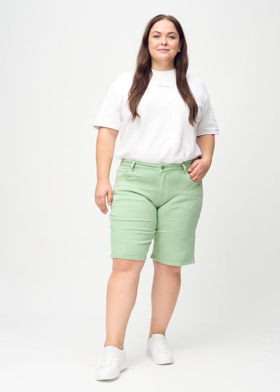 Ganzkörperbild eines Plus-Size-Models in hellgrünen regular middle shorts.