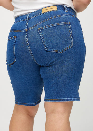 Dunkle Denim-regular middle shorts von hinten in Nahaufnahme an einem Plus-Size-Model, um Details zu zeigen.
