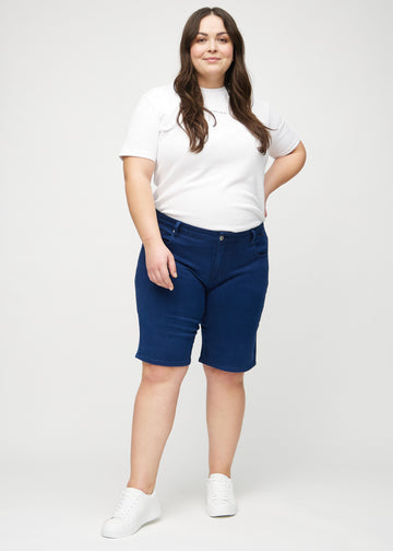 Ganzkörperbild eines Plus-Size-Models in dunkelblauen regular middle shorts.