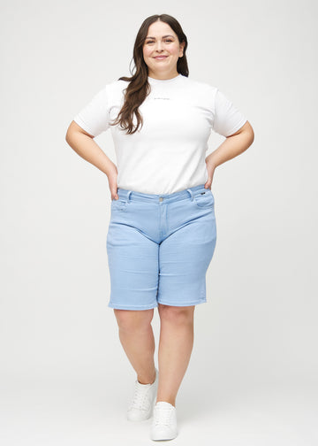 Ganzkörperbild eines Plus-Size-Models in hellblauen regular middle shorts.
