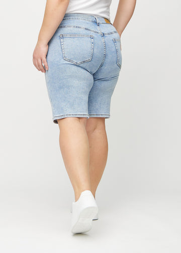 Hellblaue Denim-regular middle shorts von hinten an einem Plus-Size-Model gesehen, sodass man das gesamte Produkt sehen kann.