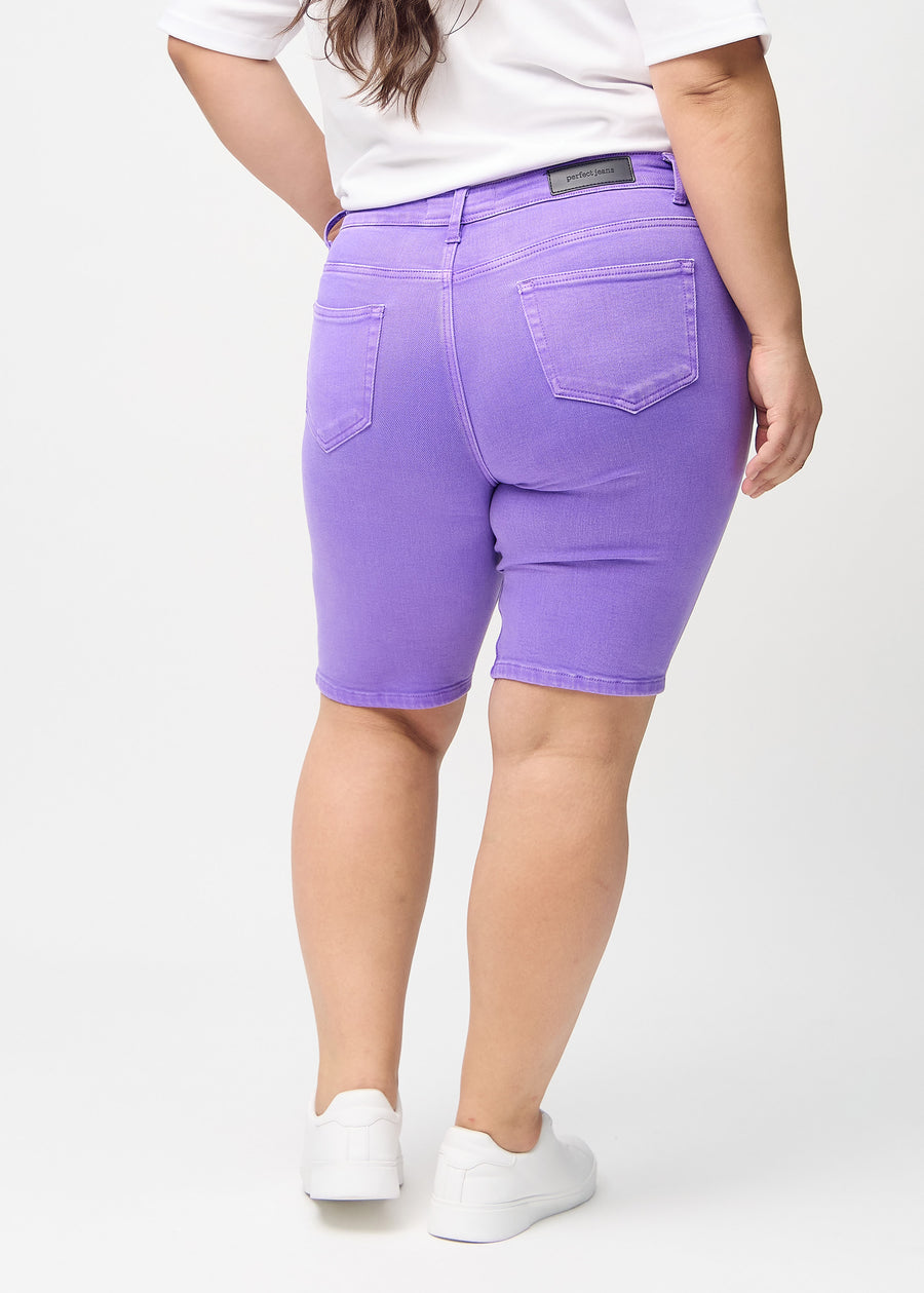 Lila skinny middle shorts von hinten an einem Plus-Size-Model gezeigt, sodass das gesamte Produkt zu sehen ist.