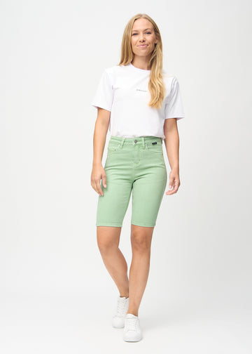 Ganzkörperbild eines Models in hellgrünen skinny middle shorts.