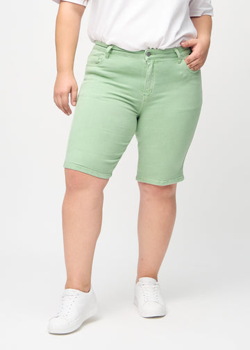 Hellgrüne skinny middle shorts, Modellname Mints, die eng am Oberschenkel anliegen und knapp über dem Knie enden, an einem Plus-Size-Model von vorne gesehen.