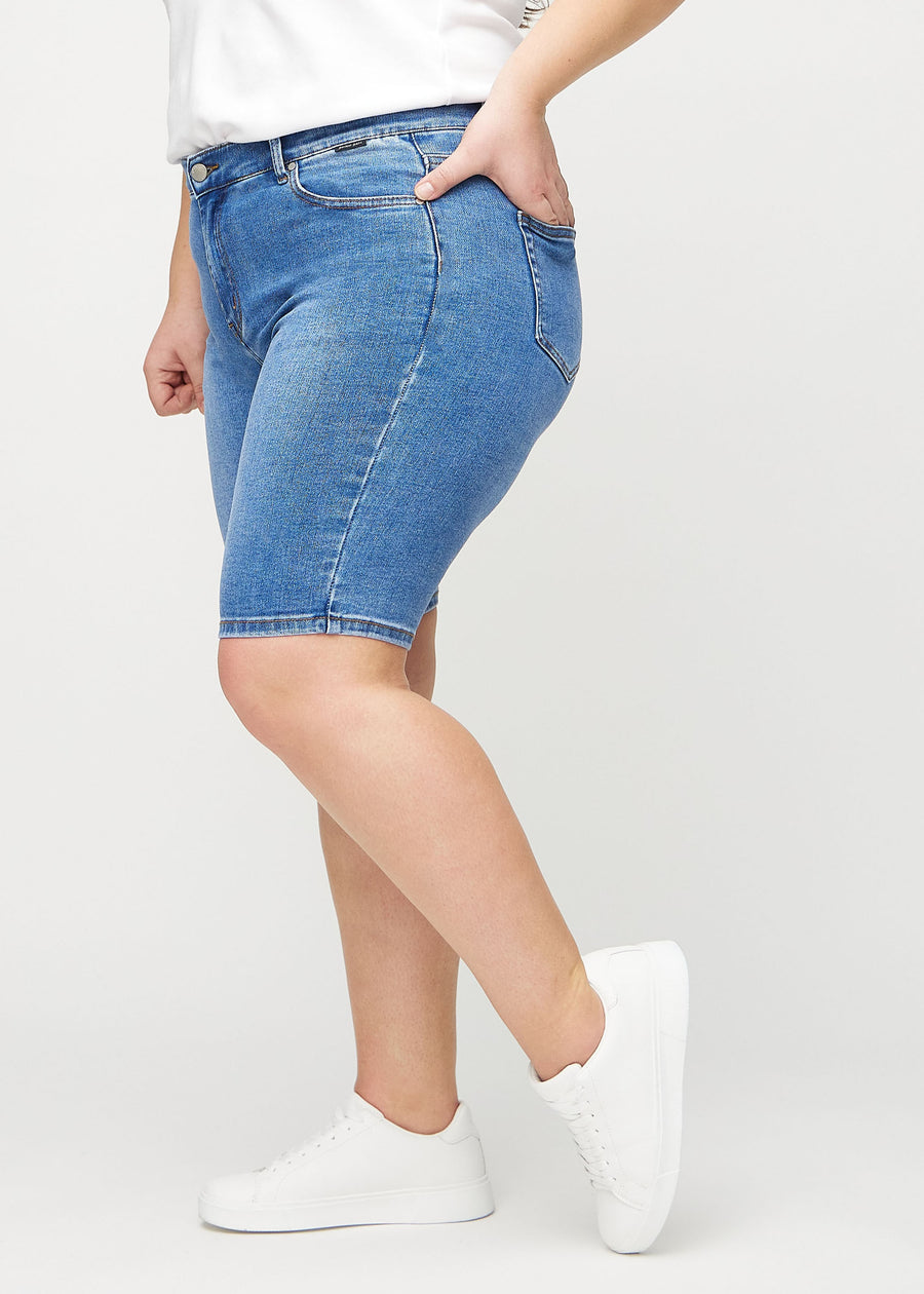 Denim skinny middle shorts von der Seite an einem Plus-Size-Model.