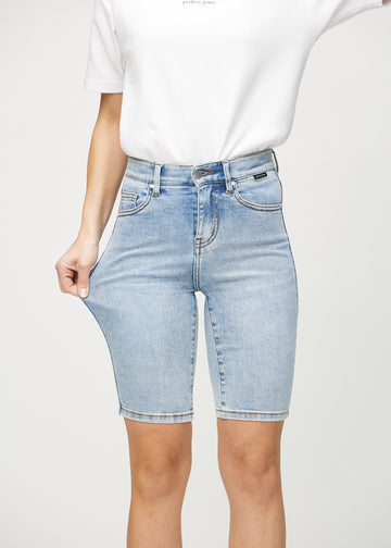 Das Model zieht die Shorts am Oberschenkel auseinander, um den Stretch zu zeigen.