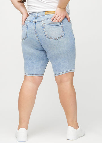 Helle Denim-skinny Middle Shorts von hinten an einem Plus-Size-Model gesehen, sodass das gesamte Produkt zu sehen ist.