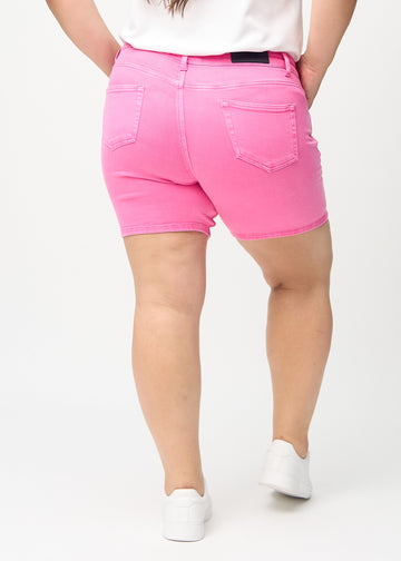 Hellrosa skinny Short Shorts von hinten an einem Plus-Size-Model gesehen, sodass man das gesamte Produkt sehen kann.