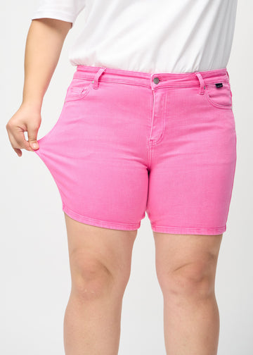 Das Plus-Size-Model zieht die Shorts am Oberschenkel auseinander, um den Stretch zu zeigen.