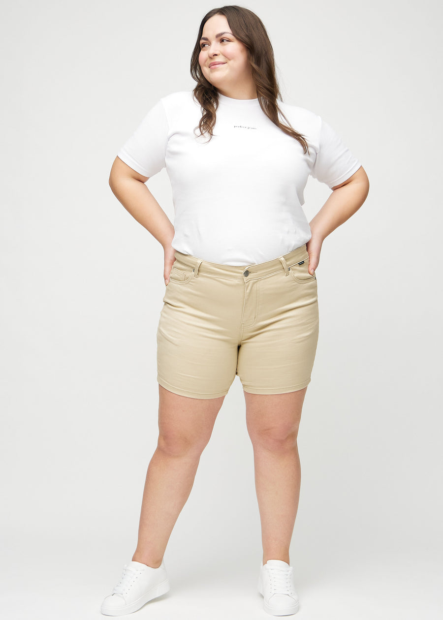 Ganzkörperbild eines Plus-Size-Models in beige skinny Short Shorts.