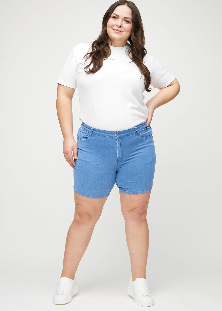 Ganzkörperbild eines Plus-Size-Models in blauen skinny Short Shorts.