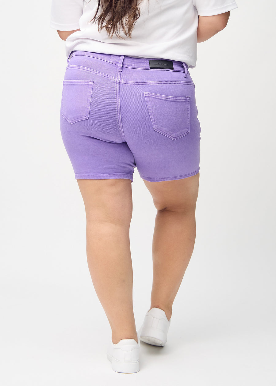 Lila skinny Short Shorts von hinten an einem Plus-Size-Model gesehen, sodass man das gesamte Produkt sehen kann.