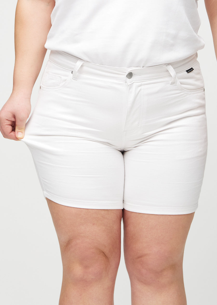 Das Plus-Size-Model zieht die Shorts am Oberschenkel auseinander, um den Stretch zu zeigen.