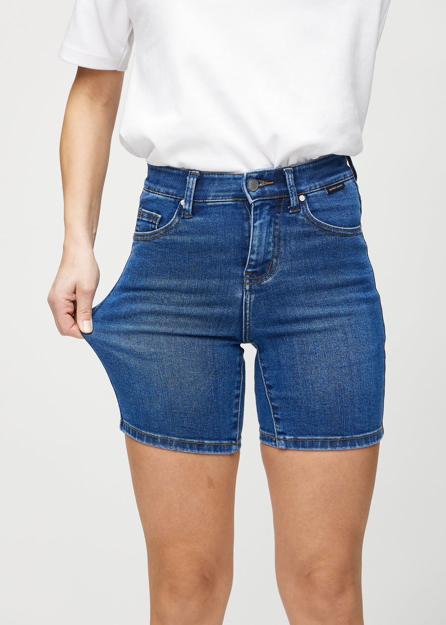 Das Model zieht die Shorts am Oberschenkel auseinander, um den Stretch zu zeigen.
