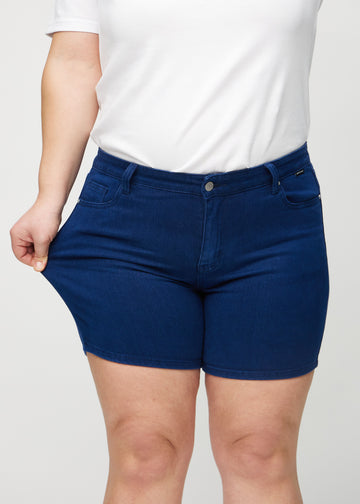 Das Plus-Size-Model dehnt die Shorts am Oberschenkel, um den Stretch zu zeigen.
