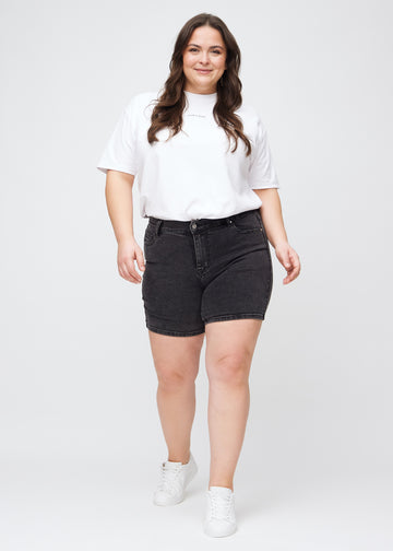 Ganzkörperbild eines Plus-Size-Models in dunkelgrauen Denim-skinny-Short Shorts.