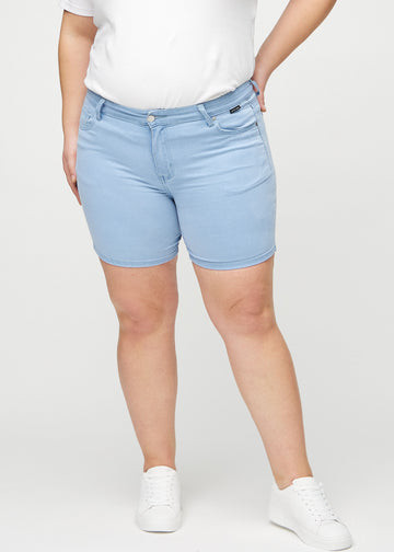 Hellblaue skinny short shorts, Modellname Skies, die eng anliegen und bis zur Mitte des Oberschenkels reichen, an einem Plus-Size-Model von vorne gesehen.