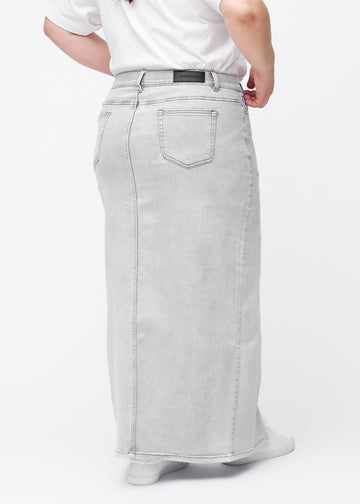 Langer hellgrauer Denimrock für Damen in der Farbe Ashes. Rückansicht an einem Plus-Size-Model, die volle Länge des Rocks ist zu sehen.