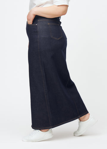 Langer tief dunkelblauer Denim-Rock für Damen in der Farbe Midnights, von der Seite auf einem Plus-Size-Model gesehen, mit sichtbarem Schlitz vorne.