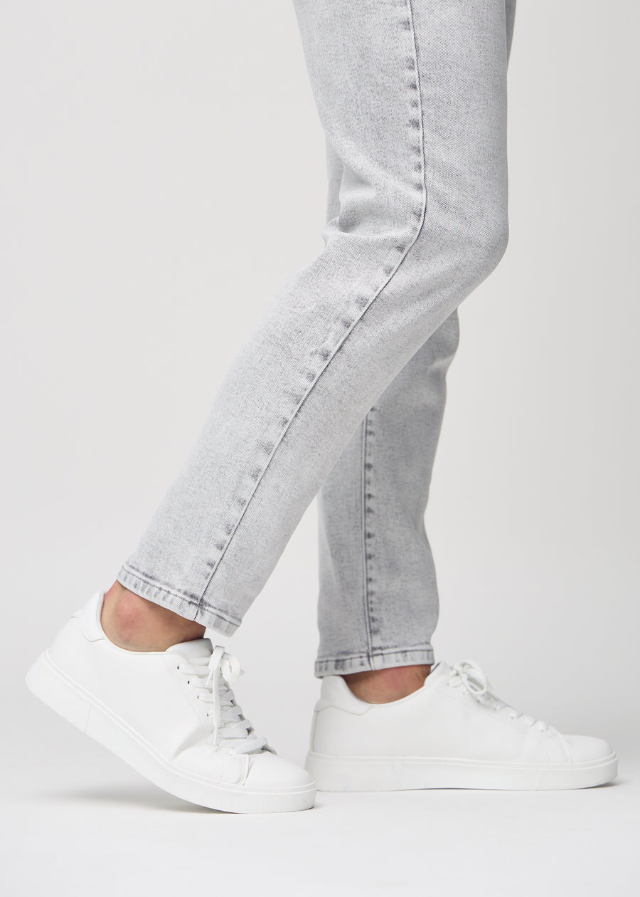 Die Knöchel eines Models, sodass man sehen kann, wie locker die Jeans sitzt.